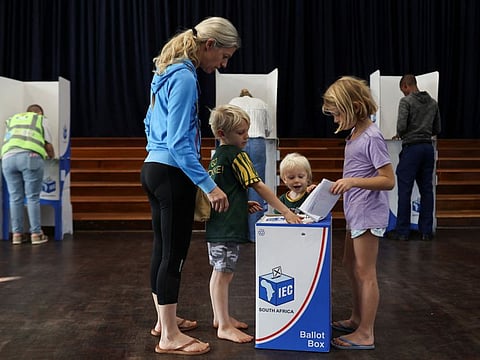 Monika Seele votes with her children in the South African elections at the Northwood Boys High School in Durban North on May 29, 2024.  