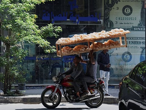 Egyptian street vendors carrying bread in Cairo.