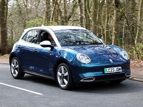A person drives a GWM ORA 03 electric car in Wycombe, Britain.