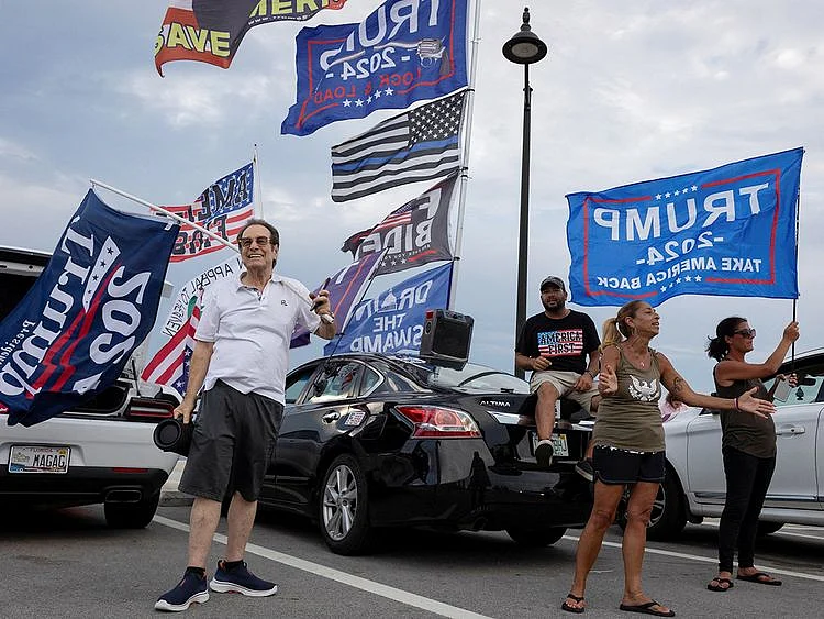 Supporters hold placards and flags 