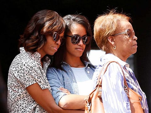 Former  US first lady Michelle Obama hugs her daughter Malia alongside Marian Robinson, Michelle Obama's mother, as they visit the Maison Des Ecslaves, the gathering point where slaves were shipped west in the 1700s and 1800s, at Goree Island near Dakar, Senegal, June 27, 2013.