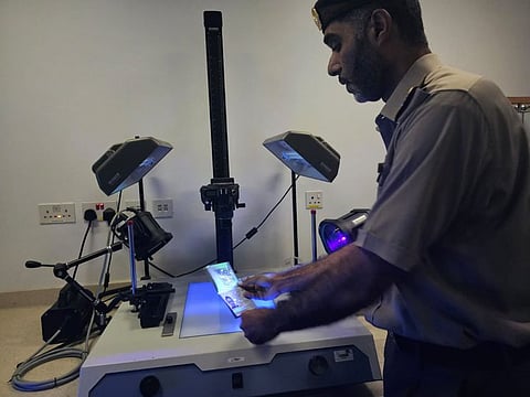 A passport being checked at the GDRFA's Document Examination Centre located at Dubai International Airport’s Terminal 1 on Monday