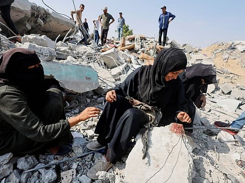 Palestinian sisters Samar and Sahar react as they search for their missing mother Amira Al Breim at the rubble of a house hit in an Israeli strike, in Khan Yunis in the southern Gaza Strip, June 3, 2024.  