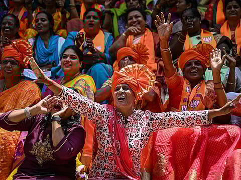 Supporters of the Bharatiya Janata Party (BJP) celebrate as they watch the vote counting results 