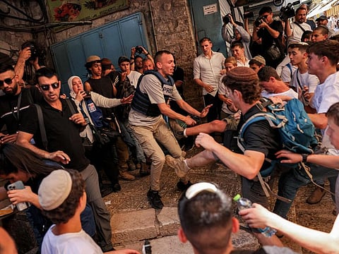 Israeli right-wing activists scuffle with a journalist during a march commemorating Jerusalem Day in the old city of Jerusalem on June 5, 2024. 