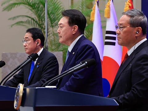 South Korean President Yoon Suk Yeol (center) speaks during a joint news conference with Japanese Prime Minister Fumio Kishida (left) and Chinese Premier Li Qiang at the guesthouse of the former presidential office, Cheong Wa Dae, in Seoul on Monday. 