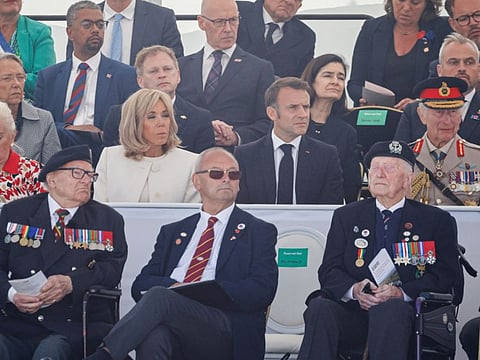 French President's wife Brigitte Macron, France's President Emmanuel Macron, Britain's King Charles III, former French prime minister Elisabeth Borne (3rd row left) and British veterans (front) attend the UK Ministry of Defence and the Royal British Legions commemorative ceremony marking the 80th anniversary of the World War II "D-Day" Allied landings in Normandy, at the World War II British Normandy Memorial near the village of Ver-sur-Mer which overlooks Gold Beach in northwestern France, on June 6, 2024.  
