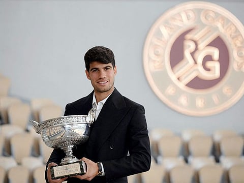 Spain’s Carlos Alcaraz poses with the trophy a day after winning the French Open tennis tournament at Roland Garros in Paris on June 10, 2024. Alcaraz defeated Alexander Zverev 6-3, 2-6, 5-7, 6-1, 6-2 on June 9 to become the youngest man to win Grand Slam titles on all three surfaces.