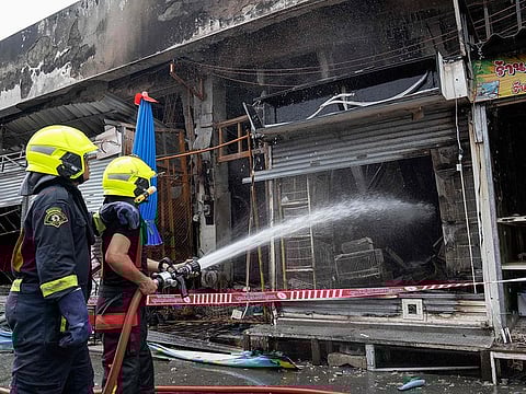 Firefighters try to extinguish a fire at a pet market next to Chatuchak market in Bangkok on June 11, 2024. A fire ripped through pet shops next to Bangkok's famed Chatuchak market early June 11, killing caged dogs, cats, birds and snakes, and damaging more than 100 stalls, police said. 