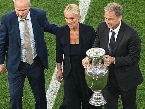 (From L) former German football player Bernard Dietz, widow of late German football player Franz Beckenbauer, Heidi Beckenbauer, and former German football player Juergen Klinsmann bring the Euro 2024 football Championship trophy onto the pitch prior to the opening ceremony of the UEFA Euro 2024 football Championship, prior to the Group A match between Germany and Scotland at the Munich Football Arena in Munich on June 14, 2024. 