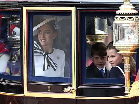 Britain's Catherine, Princess of Wales, smiles next to Britain's Princess Charlotte of Wales (R) and Britain's Prince Louis of Wales (C) inside the Glass State Coach on their way to Horse Guards Parade for the King's Birthday Parade "Trooping the Colour" in London on June 15, 2024. 
