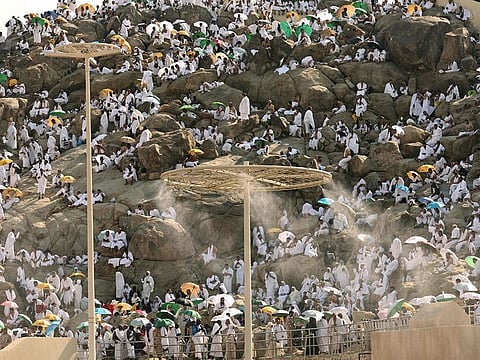 Mist dispensers refreshen pilgrims as they walk up Saudi Arabia's Mount Arafat, also known as Mount of Mercy, during the Hajj pilgrimage on June 15, 2024. 