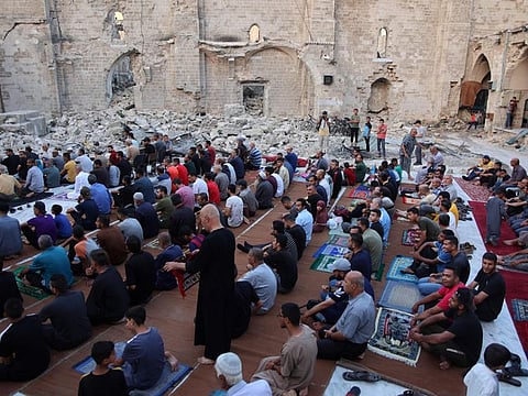 Palestinians perform the Eid morning prayer in the courtyard of Gaza City's historic Omari Mosque, which was heavily damaged in Israeli bombardment during the ongoing battles between Israel and Hamas, on June 16, 2024.  