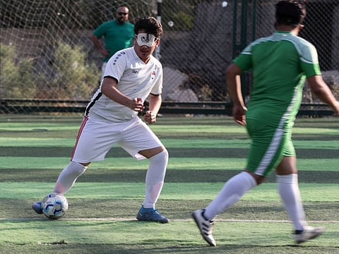 Members of Iraq's first national football team for the visually impaired train at a sports club in Baghdad.