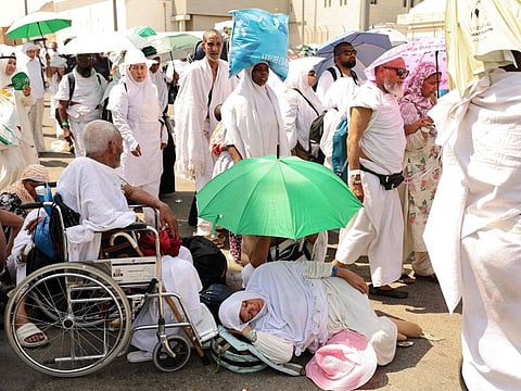 A woman effected by the scorching heat rests as pilgrims arrive to perform the symbolic 'stoning of the devil' ritual  in Mina, near Mecca, on June 16, 2024. 