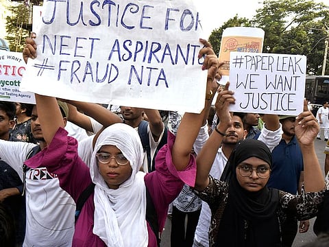 Students stage a protest against the alleged irregularities in the NEET-UG examination results and demand re-examination, in Kolkata on Monday