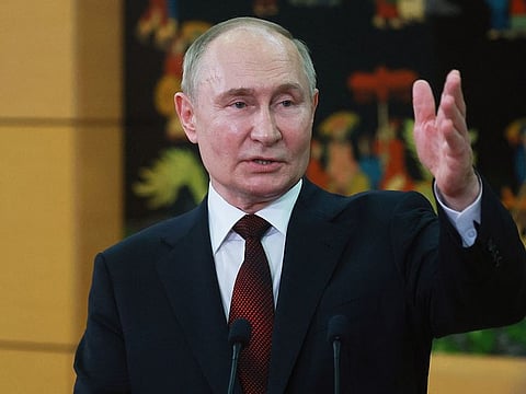 In this pool photograph distributed by the Russian state agency Sputnik, Russia's President Vladimir Putin speaks with Russian media before his departure at the Noi Bai International Airport in Hanoi on June 21, 2024.  