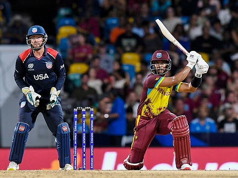 West Indies' Shai Hope hits a six as USA's Andries Gous (L) watches during the ICC men's Twenty20 Cricket World Cup 2024 Super Eight at Kensington Oval in Bridgetown, Barbados on June 21, 2024.  