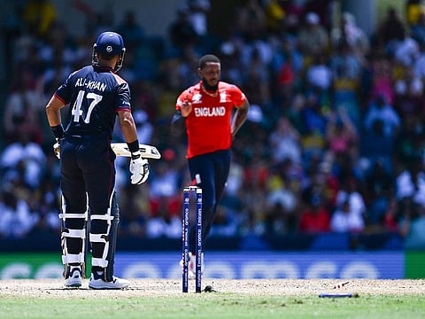 USA's Muhammad Ali-Khan looks after being clean bowled by England's Chris Jordan (R) during the ICC men's Twenty20 World Cup 2024 Super Eight cricket match between USA and England at Kensington Oval in Bridgetown, Barbuda on June 23, 2024.