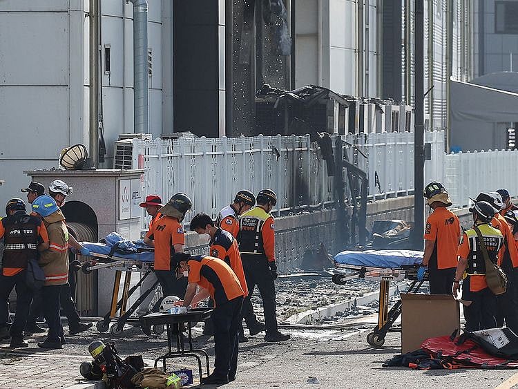 Emergency personnel carry the body of a person killed in a deadly fire at a lithium battery factory in Hwaseong on June 24, 2024.  