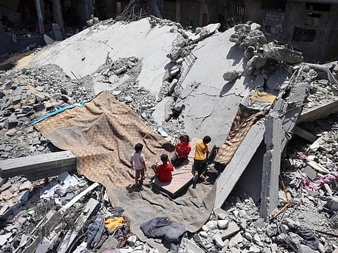 Palestinians children play on the site of a destroyed building in the Nuseirat refugee camp, in the central Gaza Strip on June 15, 2024, amid the ongoing conflict between Israel and the Palestinian Hamas militant group.  