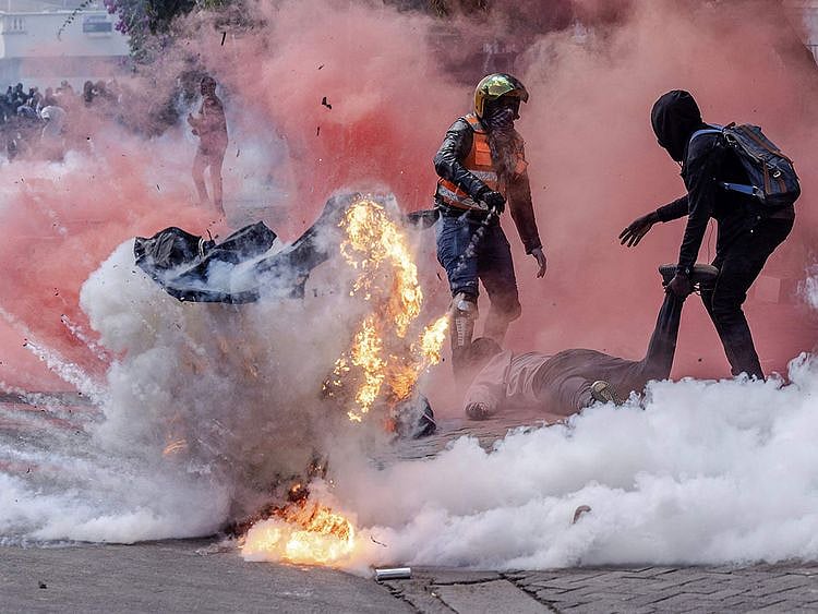 A tear gas canister explodes as protesters try to help injured people outside the Kenya Parliament during a nationwide strike to protest against tax hikes and the Finance Bill 2024 in downtown Nairobi, on June 25, 2024. 