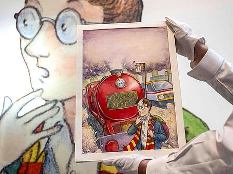 An art handler holds Thomas Taylor’s original cover art for J.K. Rowling's “Harry Potter and the Philosopher’s Stone” at Sotheby’s in New York.