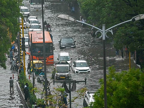 Vehicles make their way through flooded streets after heavy rains in New Delhi on June 28, 2024. 