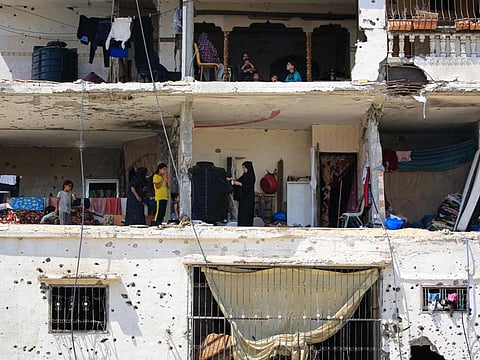 Palestinians families return to their badly damaged homes in an apartment block in Khan Younis, in the southern Gaza Strip on June 30, 2024, amid the ongoing conflict between Israel and the Palestinian Hamas militant group.  
