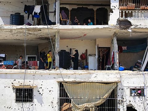 Palestinians families return to their badly damaged homes in an apartment block in Khan Younis, in the southern Gaza Strip on June 30, 2024, amid the ongoing conflict between Israel and the Palestinian Hamas militant group.  