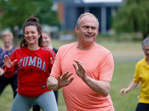 Ed Davey, leader of the Liberal Democrats, takes part in a Zumba exercise class during a general election campaign event at a park in Wokingham, UK, on Monday, July 1, 2024.  