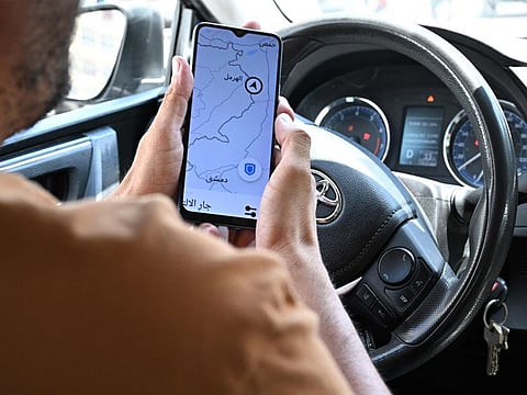 Lebanese Uber driver Hussein Khalil shows his GPS jammed geolocation on the Uber application showing the area of Hermel in Lebanon's eastern Bekaa valley, as he sits in his vehicle in Beirut's Hamra street.  