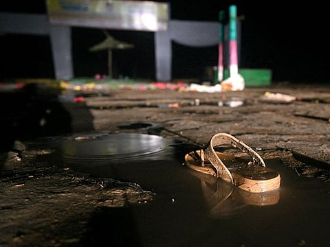 Discarded clothing and lost shoes were scattered across the muddy site, an open field alongside a highway.
