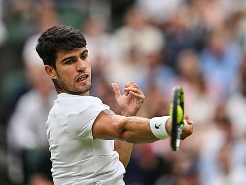 Spain's Carlos Alcaraz returns the ball to US player Frances Tiafoe during their men's singles tennis match.