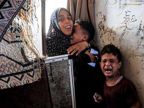 A family reacts after Israeli bombardment as they take refuge at the Jaouni school run by the UN Relief and Works Agency for Palestine Refugees (UNRWA) in Nuseirat in the central Gaza Strip on July 6, 2024 amid the ongoing conflict in the Palestinian territory between Israel and Hamas. (Photo by Eyad BABA / AFP)