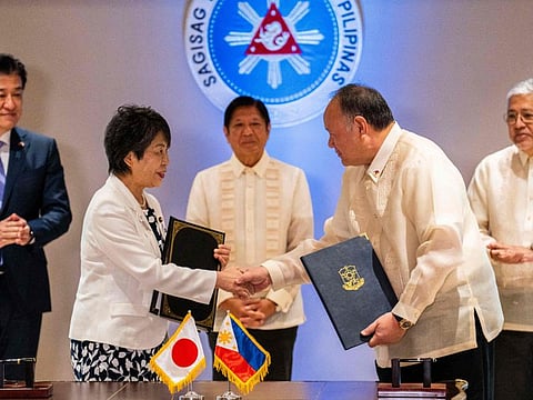 Japan's Foreign Minister Yoko Kamikawa and Philippine Defence Minister Gilberto Teodoro shake hands after signing the Reciprocal Access Agreement at the Malacanang Palace in Manila on July 8, 2024.  