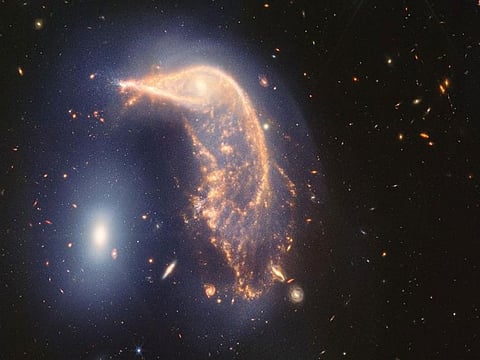 Two interacting galaxies known as Arp 142 observed in near- and mid-infrared light. At left is NGC 2937, nicknamed the Eg
