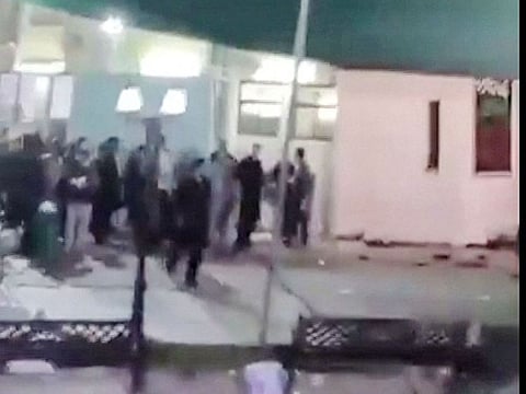 This image grab from a UGC video taken on July 16, 2024 shows people fleeing the scene of a shooting at a mosque in the Al Wadi Al Kabir area in the east of Oman's capital Muscat.  