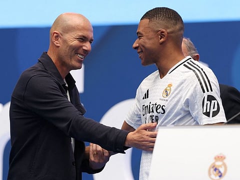 French forward Kylian Mbappe (centre) is congratulated by French former football player Zinedine Zidane during a first appearance as a Real Madrid player at the Santiago Bernabeu Stadium in Madrid on Tuesday.