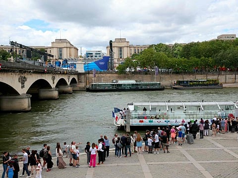 Visitors queue to board a river bus boat on the Seine river with a background view of the Trocadero Olympic venue ahead of the Paris 2024 Olympic on Tuesday.