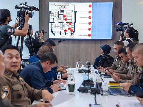 Members of the media film a forensic police layout of the room where six people were found dead the day before allegedly due to poisoning, during a press conference at Lumpini Police Station in Bangkok on July 17, 2024. 