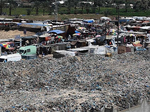 A pile of garbage surrounds a camp for displaced people in Khan Yunis in the southern Gaza Strip on July 18, 2024. 