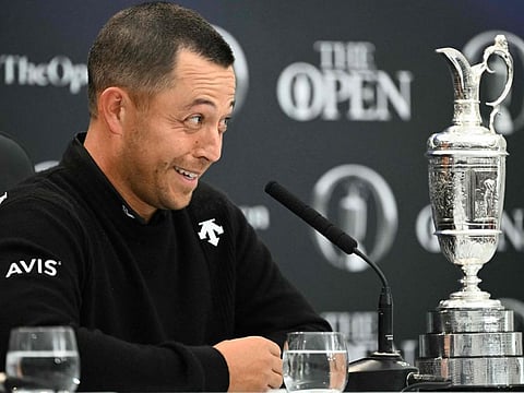 At a press conference, US golfer Xander Schauffele smiles beside the Claret Jug after winning the 152nd British Open Golf Championship at Royal Troon on Sunday.