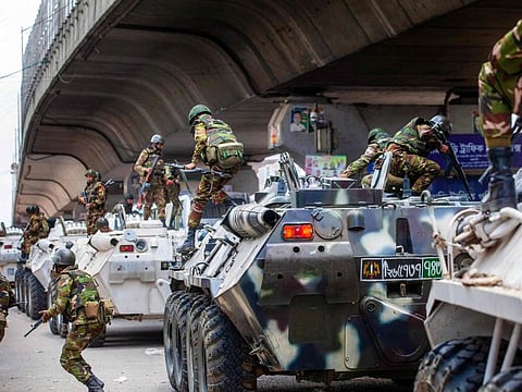 Bangladeshi soldiers disembark armoured vehicles as they patrol the streets to disperse the anti-quota protesters in Dhaka on July 20, 2024.  