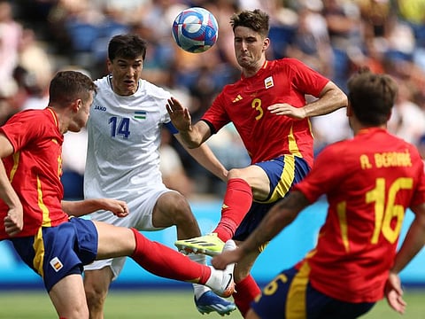 Uzbekistan's forward Eldor Shomurodov (left) fights for the ball with Spain's defender Juan Miranda  during the men's group C football match of the the Paris 2024 Olympic Games at the Parc des Princes in Paris on Wednesday.