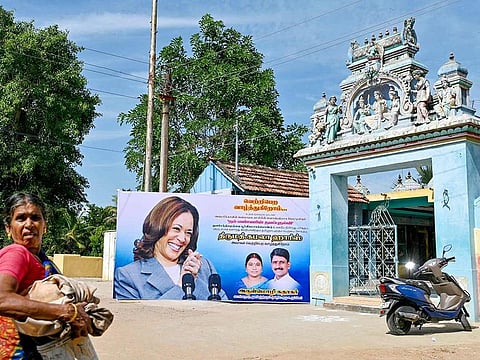 A villager walks past a poster of US Vice President Kamala Harris in her ancestral village of Thulasendrapuram in the southern Indian state of Tamil Nadu on July 23, 2024, after she was endorsed for the fall presidential election. 