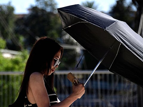 A tourist holds an umbrella to shelter from the sun in Seville.