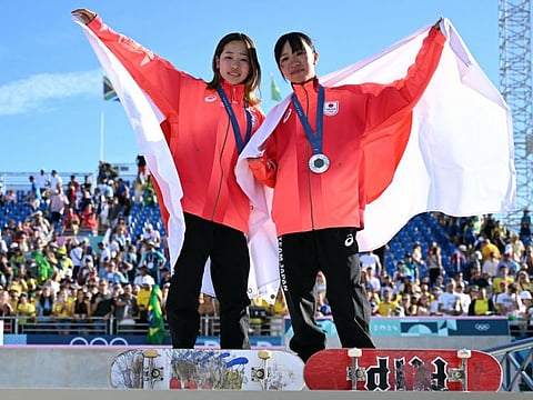 Gold medallist Japan's Coco Yoshizawa (left) and silver medallist Japan's Liz Akama stand on the podium after the victory ceremony for the women's street skateboarding event during the Paris 2024 Olympic Games at La Concorde in Paris on Sunday.
