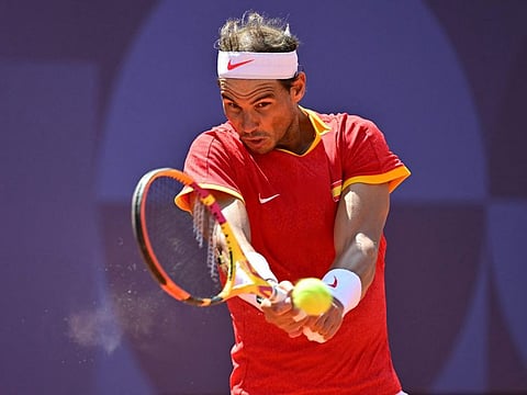 TOPSHOT - Spain's Rafael Nadal returns to Serbia's Novak Djokovic during their men's singles second round tennis match on Court Philippe-Chatrier at the Roland-Garros Stadium at the Paris 2024 Olympic Games, in Paris on July 29, 2024. (Photo by Martin  BERNETTI / AFP)