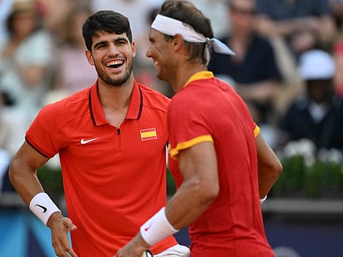 Spain's Carlos Alcaraz (left) shares a laugh with Spain's Rafael Nadal during their match against Netherlands' Tallon Griekspoor and Netherlands' Wesley Koolhof on Court Suzanne-Lenglen at the Roland-Garros Stadium on Tuesday.